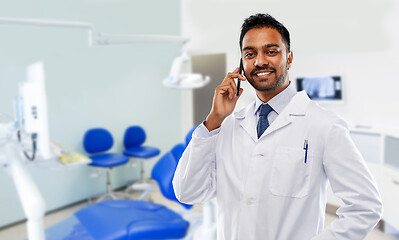 Image showing dentist calling on smartphone at dental clinic