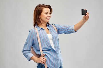 Image showing woman with backpack taking selfie by smartphone