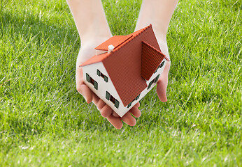 Image showing close up of hands holding house or home model