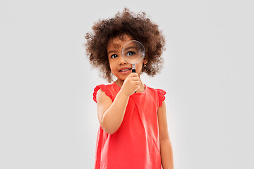 Image showing african girl looking through magnifying glass