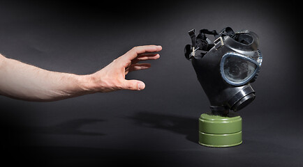 Image showing Man in room, trying to reach for vintage gasmask - Green filter 