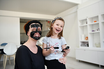 Image showing mother and daughter at home making facial mask beauty treatment