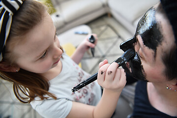 Image showing mother and daughter at home making facial mask beauty treatment