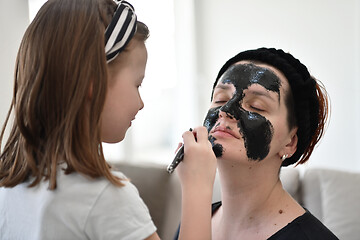 Image showing mother and daughter at home making facial mask beauty treatment