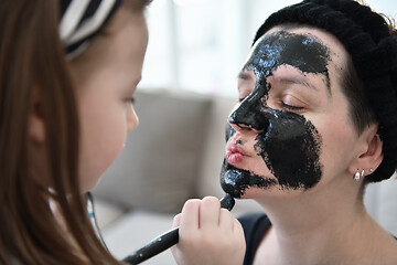 Image showing mother and daughter at home making facial mask beauty treatment