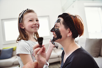 Image showing mother and daughter at home making facial mask beauty treatment