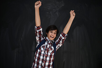 Image showing happy arab teenager  celebrating against black chalkboard