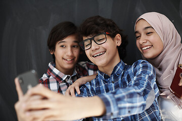 Image showing group of arab teens taking selfie photo on smart phone