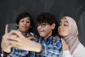 Image showing group of arab teens taking selfie photo on smart phone