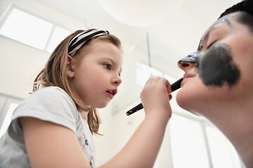 Image showing mother and daughter at home making facial mask beauty treatment