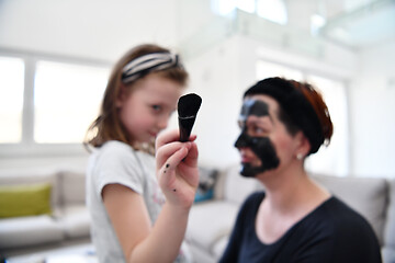 Image showing mother and daughter at home making facial mask beauty treatment
