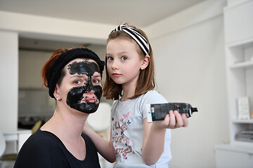 Image showing mother and daughter at home making facial mask beauty treatment