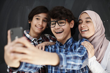 Image showing group of arab teens taking selfie photo on smart phone