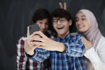 Image showing group of arab teens taking selfie photo on smart phone