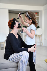 Image showing mother and daughter at home making facial mask beauty treatment