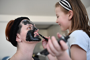 Image showing mother and daughter at home making facial mask beauty treatment