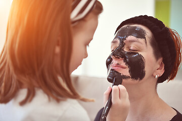 Image showing mother and daughter at home making facial mask beauty treatment