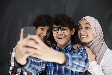 Image showing group of arab teens taking selfie photo on smart phone