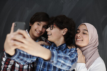 Image showing group of arab teens taking selfie photo on smart phone