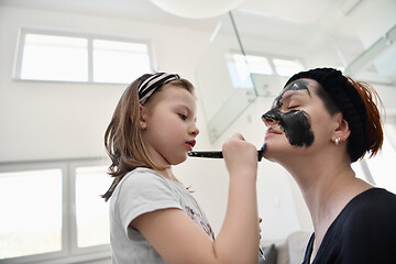 Image showing mother and daughter at home making facial mask beauty treatment