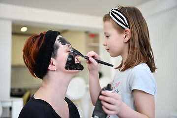 Image showing mother and daughter at home making facial mask beauty treatment