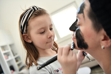 Image showing mother and daughter at home making facial mask beauty treatment