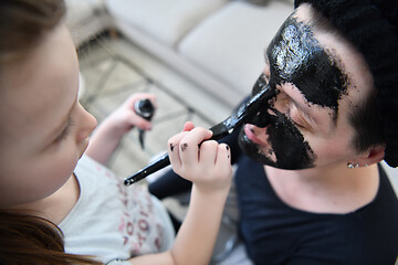 Image showing mother and daughter at home making facial mask beauty treatment