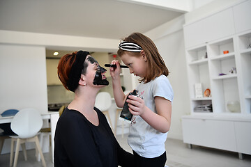 Image showing mother and daughter at home making facial mask beauty treatment