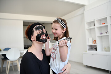 Image showing mother and daughter at home making facial mask beauty treatment