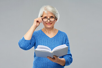 Image showing senior woman in glasses reading book