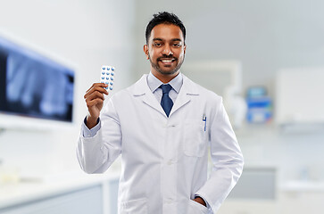 Image showing indian male dentist with pills at dental clinic