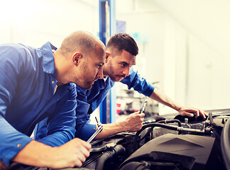 Image showing mechanic men with wrench repairing car at workshop