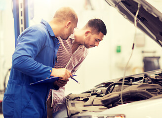 Image showing auto mechanic with clipboard and man at car shop