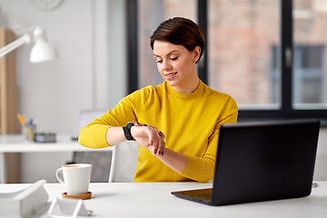 Image showing happy businesswoman using smart watch at office