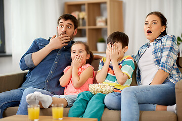 Image showing scared family with popcorn watching horror on tv