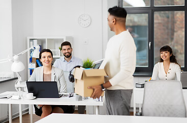 Image showing office workers looking at colleague quitting job