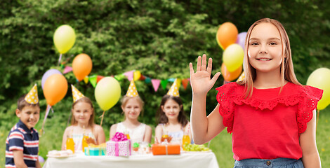 Image showing smiling girl waving hand at birthday party in park