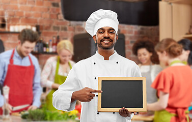 Image showing happy indian chef with chalkboard at cooking class