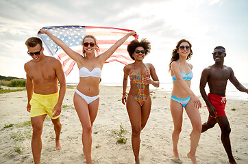 Image showing happy friends with american flag on summer beach
