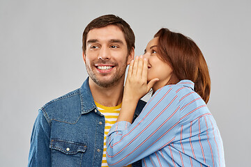 Image showing happy couple whispering over grey background