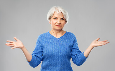 Image showing senior woman having no idea and shrugging