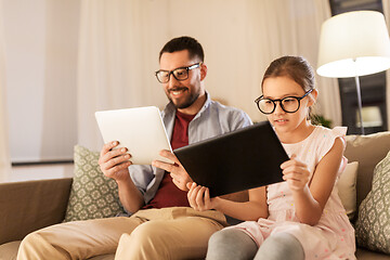 Image showing father and daughter with tablet computers at home