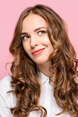 Image showing The happy business woman standing and smiling against pink background.