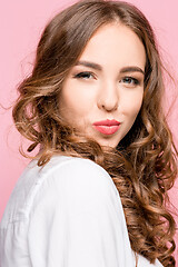 Image showing Portrait of attractive cute girl with bright makeup with kiss isolated over pink background