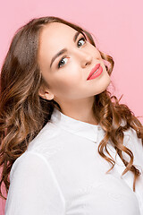 Image showing The happy business woman standing and smiling against pink background.