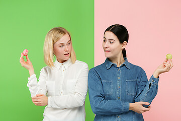 Image showing Young beautiful women holding macaroons pastry in her hands