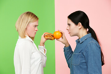 Image showing Diet. Dieting concept. Healthy Food. Beautiful Young Women choosing between fruits and unhelathy fast food