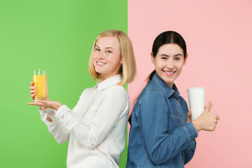 Image showing Diet. Dieting concept. Healthy Food. Beautiful Young Women choosing between fruit orange juice and unhelathy carbonated sweet drink