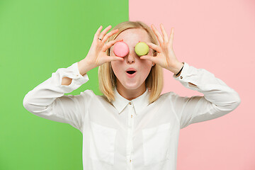 Image showing Young beautiful woman holding macaroons pastry in her hands