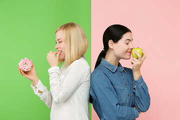 Image showing Diet. Dieting concept. Healthy Food. Beautiful Young Women choosing between fruits and unhelathy cake